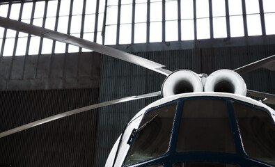 Twin-turbine helicopter is in the hangar. Rotor blades, turbines and cockpit. Selective focus. © vladk213