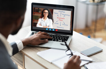 Black businessman working using laptop on his workplace, having training