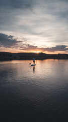 Man standing on a stand up paddling board during the sunset at Lake Mead in Nevada, USA