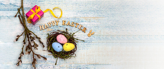 Gift boxes with ribbons. Happy Easter. Willow twigs. Holy Easter. Blue turquoise background. Easter eggs in the nest.