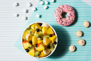 Fruit salad and sweets on a blue background
