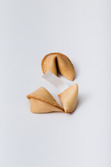 Broken fortune cookie with message paper on a white background