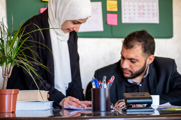 Muslim women ask for support and checking her work results with