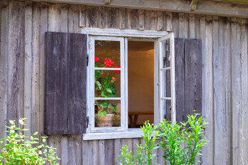 Old window in aged wooden house. Wooden wall from boards