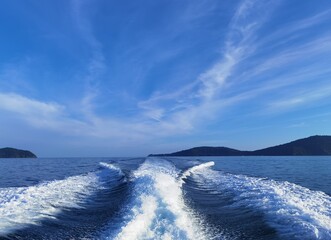 Blue waves in the ocean behind speedboat