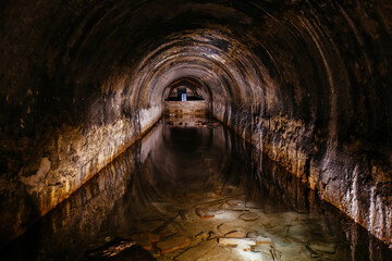 Flooded vaulted sewer tunnel with water reflection