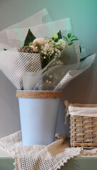Fantasy bouquet in a blue planter with natural decor in a room with a gray wall, Scandinavian style