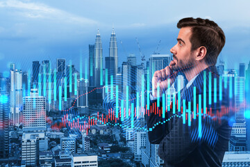 A young Caucasian handsome trader and stock market analyst in suit dreaming about market behavior and forecast in crisis. Trading at corporate finance fund. Forex chart. Kuala Lumpur. Double exposure