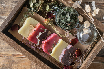 Assorted handmade cosmetic soaps on a wooden background.