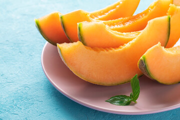 Naklejka na ściany i meble Slices of juicy cantaloupe melon on a plate.