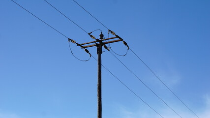 electrical post with power lines against sky