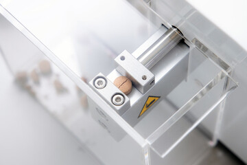 Pill broken in tablet hardness tester machine. Drug quality test in manufacturing laboratory concept.  