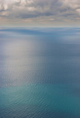Dark blue sea surface under a cloudy sky.