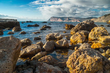 Large stones going up from the water on the seashore.