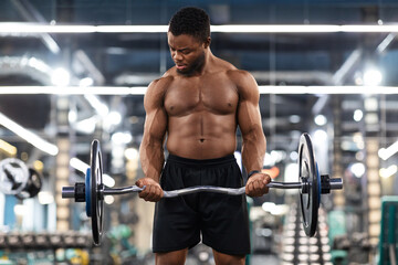 Naklejka na ściany i meble Athletic black man working on arms and chest musculs