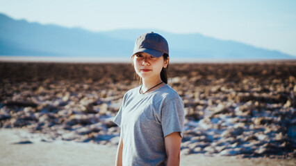 Asian girl with a cap smiling in the badwater basin in the Death Valley, California, USA
