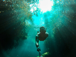 Man takes selfie while freediving in Casa Cenote in Tulum, Quintana Roo, Mexico - obrazy, fototapety, plakaty