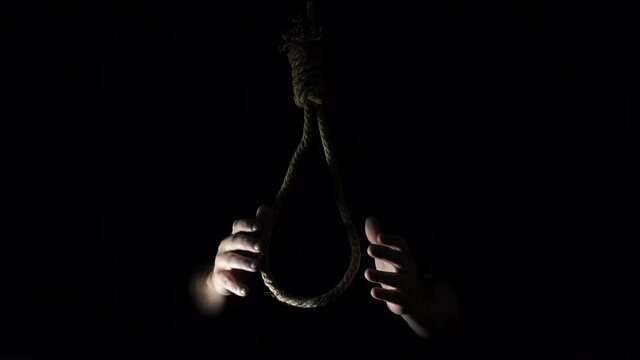 suicide loop. the gallows. the loop dangles. Rope noose with hangman knot in front of dark background