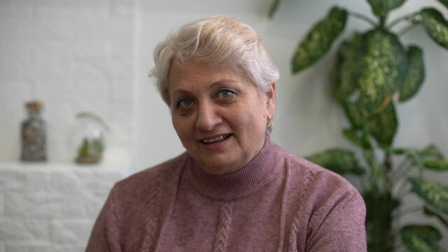 Profile side view portrait of her she nice attractive addicted focused gray-haired blonde granny playing network web virtual team game at industrial loft modern concrete style interior house flat