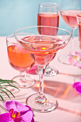 Summer tropical pink cocktail in a different glasses decorated pink orchid flowers.