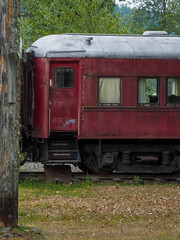 Fototapeta na wymiar Vintage red train passenger car left to deteriorate.