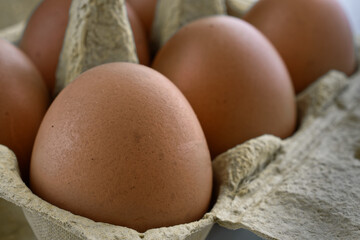 Close up of brown chicken eggs, in an egg box. Selective focus.