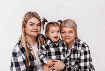 Grandmother, daughter and granddaughter, three generations of women on a white background