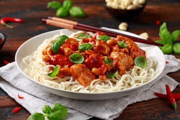 Sweet Chilli Chicken with noodles on wooden table. asian food