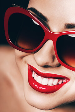 pretty smiling woman with red lips in sunglasses