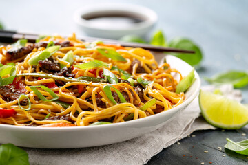 Stir fry noodles with beef and vegetable in white bowl. asian style food