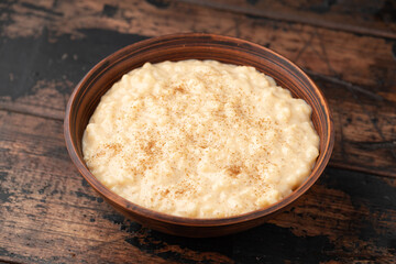 Rice pudding with cinnamon and blueberry, raspberry in rustic bowl