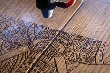 laser engraves the image of an Indian elephant on a wooden surface - 417177460