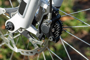 Hydraulic front disc brake on mountain bike with bicycle hub, caliper and spokes.