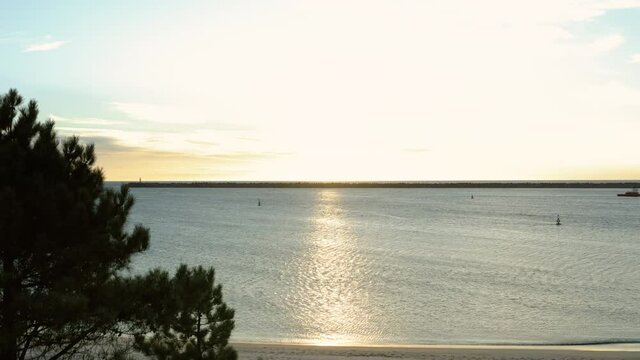 View over Coral Beach stone pier from Cabedelo Beach side at dusk - Aerial ascending shot