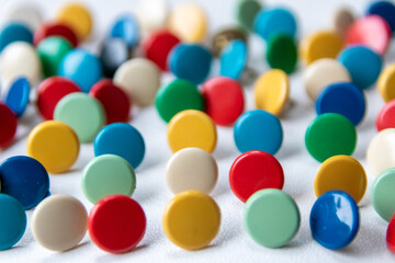 Bunch of many colorful thumbtacks as multi-color office supply metal pushpins circles in yellow, green, blue, red and white as design collection for business pins and school organization equipment