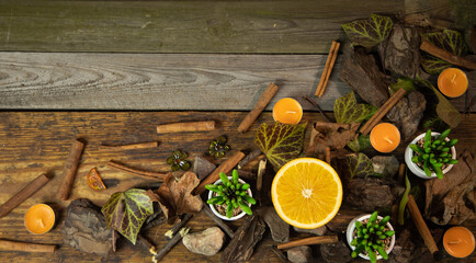 Fototapeta Tło z drewnianych desek wraz z dekoracją liście gałązki kamienie pomarańcz i laski cynamonu obraz
