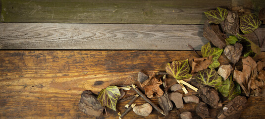Tło z drewnianych desek wraz z dekoracją liście gałązki kamienie i laski cynamonu