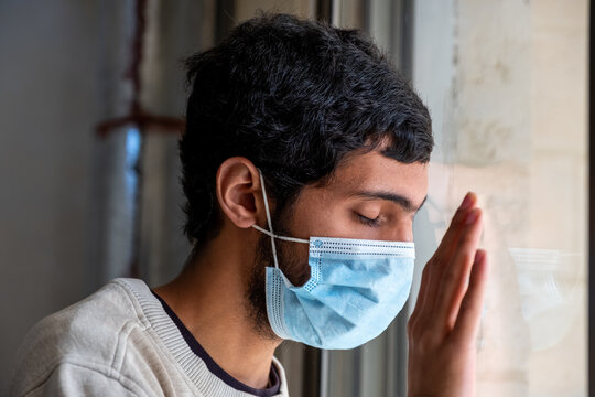 Arabic Family Looking From The Window During The Quarantine Time And Wearing Masks