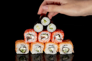 Philadelphia roll with salmon, cheese and cucumber on a black background with reflection. Sushi Philadelphia