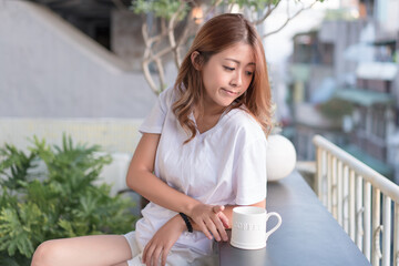 Young woman enjoying the cityscape side view from her hotel.