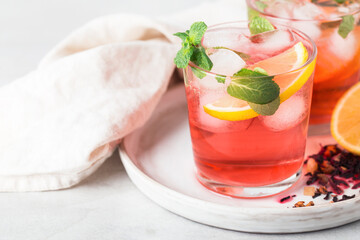 red tea karkade sparkling cold in glasses with mint, ice and lemon