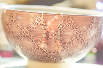 Seed and mineral stone earrings hanging on bowl