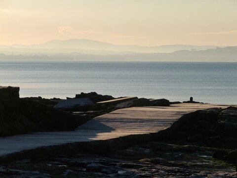 Sunrise over Ayr Bay, Scotland on a frosty cloudless winter's morning, as seen from the Ballast Bank, Troon, with the Merrick mountain visible in the  far distance