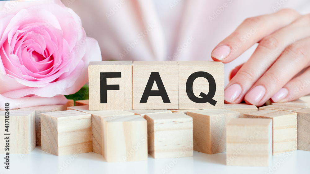 Poster faq text on wooden block in hands