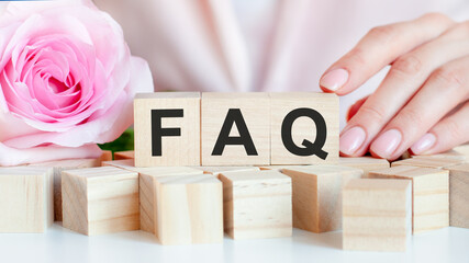 FAQ text on wooden block in hands