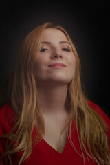 a blonde girl with an overweight plus size, a red overallposing on a dark Studio background