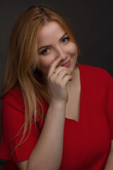 a blonde girl with an overweight plus size, a red overallposing on a dark Studio background