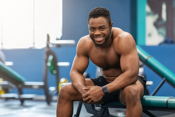 Naklejka na ściany i meble Smiling african american shirtless bodybuilder having break