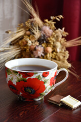 Obraz na płótnie Canvas Cup of tea with sweets against the background of dry flowers.