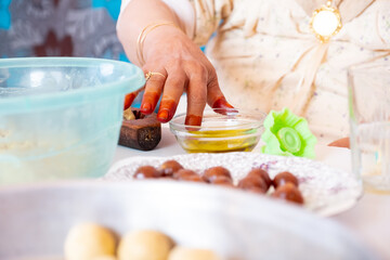 Obraz na płótnie Canvas Arabic woman hands making eid sweets ,cookiesand mamoul